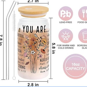 May include: A clear glass 16oz capacity tumbler with a bamboo lid and two straws. The tumbler has a floral design and inspirational text, including "You Are..." and bible verses. The tumbler is lead-free and made of borosilicate glass, suitable for both warm and cold drinks.