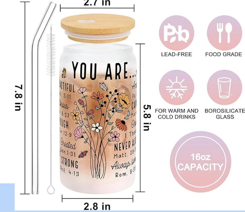 May include: A clear glass 16oz capacity tumbler with a bamboo lid and two straws. The tumbler has a floral design and inspirational text, including "You Are..." and bible verses. The tumbler is lead-free and made of borosilicate glass, suitable for both warm and cold drinks.