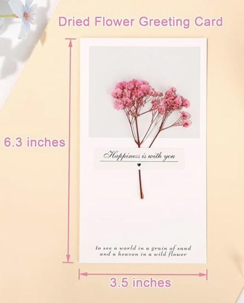May include: A white greeting card with a dried pink flower arrangement and the text "Happiness is with you". The card measures 6.3 inches by 3.5 inches.