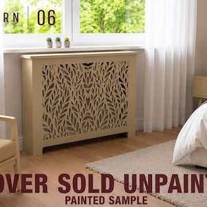 May include: A beige radiator cover featuring a decorative laser-cut leaf pattern on the front panel. The rectangular unit has a flat top surface and is positioned below a window. Text on the image reads PATTERN 06 and COVER SOLD UNPAINTED.