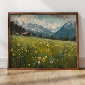 May include: A framed painting depicting a landscape with a small wooden cabin in the foreground, surrounded by a field of yellow wildflowers. The background features a mountain range with snow-capped peaks and a blue sky with clouds.