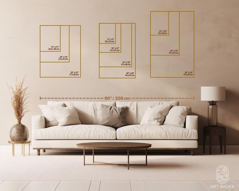 May include: A white sofa with three pillows sits in front of a beige wall with four framed images of different sizes. The images are labeled with measurements in inches and centimeters. The sofa is 90 inches or 228 centimeters wide.