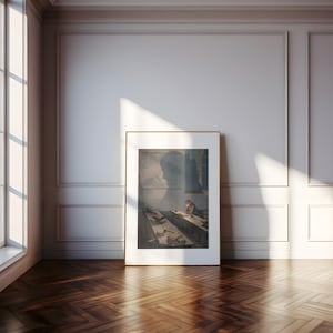 May include: A framed print of a painting depicting a person sitting at a desk in a room with a window. The person is wearing a dark coat and is writing on a piece of paper. The room is dimly lit and the window is letting in some light. The painting is in a gold frame.