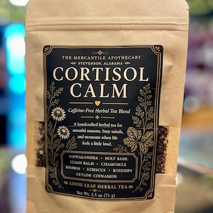 May include: A brown paper bag of "Cortisol Calm" loose leaf herbal tea. The label is black with gold accents and contains the text "The Mercantile Apothecary, Stevenson, Alabama." The bag contains 2.5 oz (71 g) of tea.