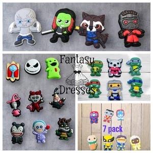 Puede incluir: Una colección de abalorios para zapatos de personajes de dibujos animados coloridos, incluyendo personajes de Marvel, las Tortugas Ninja y Pesadilla Antes de Navidad. Los abalorios son de goma y tienen una variedad de expresiones. Los abalorios están dispuestos en filas y columnas sobre un fondo blanco. El texto "Fantasy Dresses" y "7 pack" es visible en la imagen.