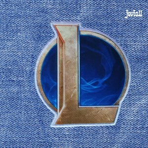 Puede incluir: Parche bordado con una "L" dorada sobre un fondo azul con remolinos, borde cosido blanco y fondo de mezclilla. El texto "Joviall" está en la esquina superior derecha. Un artículo decorativo para ropa o accesorios.