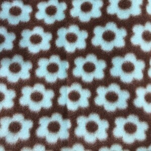 May include: Brown fabric with a repeating pattern of light blue flowers.