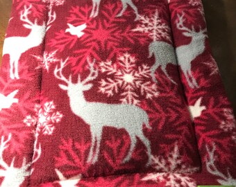 Kratmat rendieren en sneeuwvlokken op rode fleece