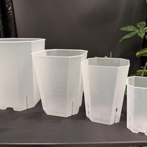 May include: A set of three ceramic mugs with a speckled, matte finish. The mugs are in shades of cream, light gray, and dark gray. Each mug has a simple, minimalist design, perfect for coffee or tea.