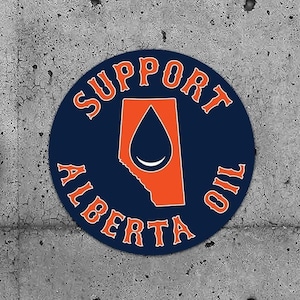 May include: Two blue and orange round stickers with the text "Support Alberta Oil" on a gray concrete wall.