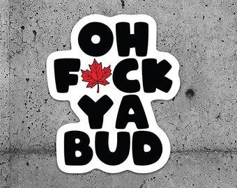 May include: Two black and white stickers with the text "Oh F*ck Ya Bud" and a red maple leaf. The stickers are on a gray concrete wall.