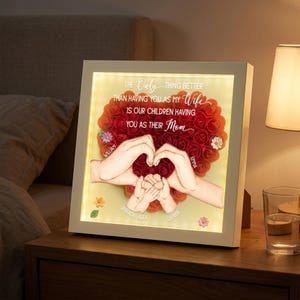 May include: A white framed, illuminated art piece with the text "The only thing better than having you as my wife is our children having you as their mom." The artwork features a heart made of red roses, hands, and children's hands.