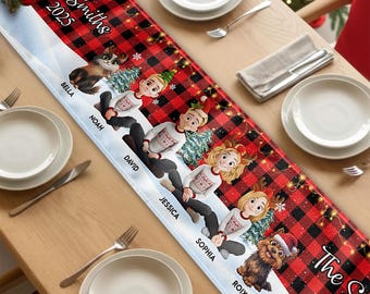 Puede incluir: Un camino de mesa personalizado con un patrón de cuadros rojos y negros, una base blanca nevada e ilustraciones de dos perros y cuatro personas con jerséis navideños. El texto dice The Smiths 2025, Bella, Noah, David, Jessica, Sophia y Roixe.