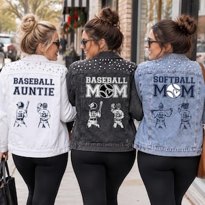 Peut inclure: Trois vestes en jean ornées de perles sur les épaules. La veste blanche porte l'inscription BASEBALL AUNTIE, la noire BASEBALL MOM et la bleue SOFTBALL MOM, chacune accompagnée d'illustrations graphiques de joueurs de baseball.