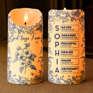 May include: Two decorative LED candles with floral and butterfly patterns. One candle has the text "God Says I am", the other spells "SOPHIA" with associated Bible verses. The candles emit a warm, inviting glow.