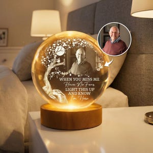 Könnte beinhalten: Ein personalisiertes Kristallkugel-Nachtlicht mit einem Foto einer Person im Inneren. Die Kugel ist beleuchtet und steht auf einem Holzsockel. Der Text auf der Kugel lautet: "WHEN YOU MISS ME, HAVE NO FEAR, LIGHT THIS UP AND KNOW I'M HERE."