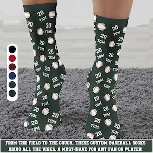 Op de afbeelding: Donkergroene honkbalsokken met een herhalend patroon van honkballen, het nummer "20" en de naam "TOM". De sokken hebben een wit en rood honkbalontwerp. De tekst onderaan luidt: "FROM THE FIELD TO THE COUCH, THESE CUSTOM BASEBALL SOCKS BRING ALL THE VIBES. A MUST-HAVE FOR ANY FAN OR PLAYER!"