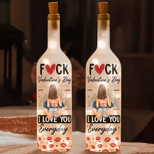 May include: Two clear glass bottles with cork tops and white lights inside. The bottles have a graphic of a couple with the text "F*CK Valentine's Day" and "I Love You Everyday" printed on them.