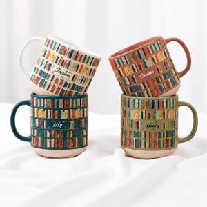 May include: Four ceramic mugs featuring a colourful bookshelf pattern with various book spines. Each mug is personalised with a name: Jessica, Sophia, Lily, or Henry. The mugs have speckled, light-coloured bases and matching coloured handles.