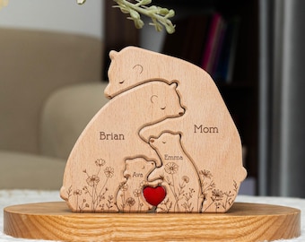 May include: Wooden bear family cutout with the names Mom, Brian, Emma, and Ava. The bears are arranged in a hug with a red heart in the center. The cutout is on a wooden base.