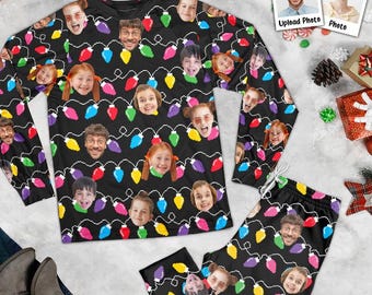 Può includere: Un completo composto da una maglia a maniche lunghe e pantaloni neri, caratterizzato da un motivo ripetuto di lampadine natalizie colorate alternate a volti personalizzati stampati su tutto il tessuto.