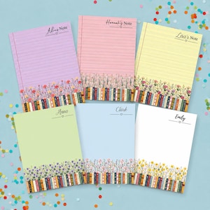 May include: Six rectangular personalised notepads in purple, pink, yellow, light green, light blue, and white. Each notepad features a bottom border of colourful books and wildflowers, with a name and the word Note printed at the top.
