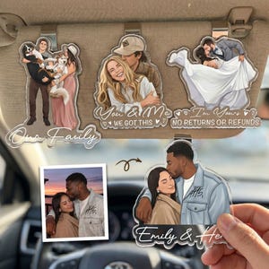 Puede incluir: Cuatro adornos de acr&iacute;lico personalizados para el parasol del coche con ilustraciones de parejas y familias. Los dise&ntilde;os incluyen una familia con perros, una pareja con el texto "You & Me WE GOT THIS", una boda y una pareja con "Emily &..."