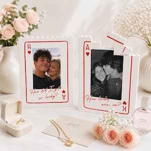 Pode incluir: Duas molduras retangulares de blocos de montar brancas projetadas como cartas de baralho. A moldura esquerda apresenta uma foto de um casal e o texto How did I get so lucky? A moldura direita apresenta uma foto de um casal e o texto How lucky are we?