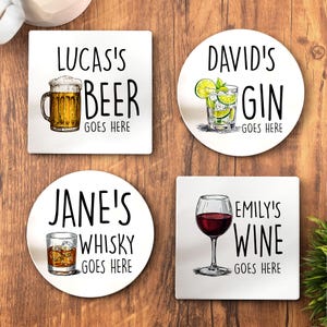 May include: Four white drink coasters with black text and illustrations. One square coaster says Lucas's Beer Goes Here with a beer mug. One round coaster says David's Gin Goes Here with a gin glass. One round coaster says Jane's Whisky Goes Here with a whisky glass. One square coaster says Emily's Wine Goes Here with a wine glass.