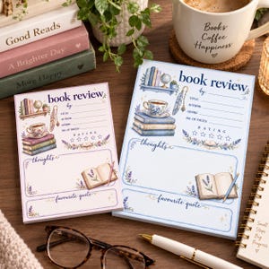 May include: Two rectangular paper pads for book reviews, one with a light pink border and one with a light blue border. Both feature illustrations of a bookshelf, a teacup, a stack of books, a quill, and an open book with lavender sprigs.