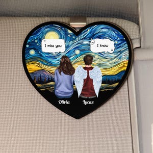 May include: Heart-shaped ornament featuring a couple with angel wings, set against a starry night sky reminiscent of Van Gogh's style. The ornament includes the phrases "I miss you" and "I know", with the names "Olivia" and "Lucas" below the figures.