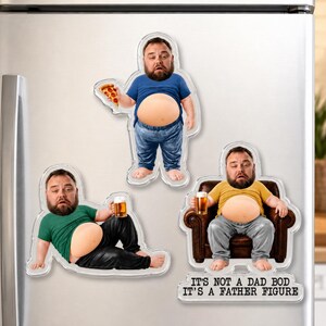 Peut inclure: Trois aimants de réfrigérateur en acrylique représentant un homme barbu avec un ventre proéminent. Un aimant le montre debout avec une pizza, un autre allongé avec une bière, et le troisième assis dans un fauteuil avec le texte : IT'S NOT A DAD BOD IT'S A FATHER FIGURE.