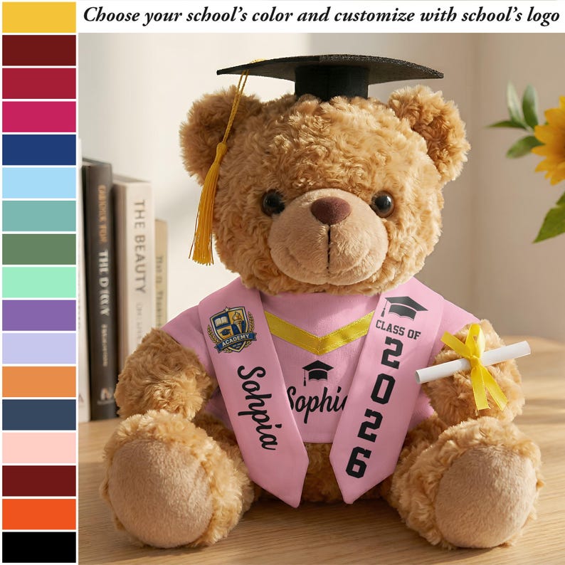 K&ouml;nnte beinhalten: Ein brauner Teddyb&auml;r mit Abschlusskappe und rosa Sch&auml;rpe mit der Aufschrift "Class of 2026" und "Sophia". Der B&auml;r h&auml;lt ein Diplom, das mit einem gelben Band gebunden ist. Der Text "W&auml;hlen Sie die Farbe Ihrer Schule und passen Sie sie mit dem Logo der Schule an" ist sichtbar.