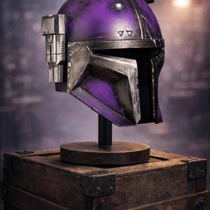 Peut inclure: Casque futuriste violet et argent&eacute;, probablement un accessoire ou un objet de collection, expos&eacute; sur un socle en bois pos&eacute; sur une bo&icirc;te en bois. Le casque pr&eacute;sente un design angulaire et une visi&egrave;re. La palette de couleurs comprend des nuances de violet et d'argent.