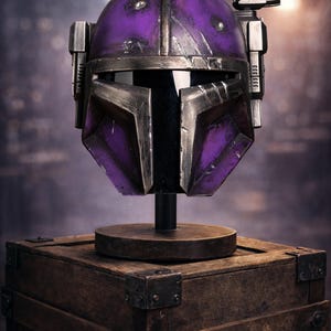 Peut inclure: Casque violet et argent&eacute;, probablement pour le cosplay ou l'affichage, mont&eacute; sur un support en bois au-dessus d'une bo&icirc;te en bois. Le casque a un aspect vieilli avec des signes d'usure. L'arri&egrave;re-plan est flou, sugg&eacute;rant un cadre de studio.