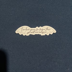May include: A white sticker with a black outline of wings and the text "I've been yours for longer than you could even imagine".