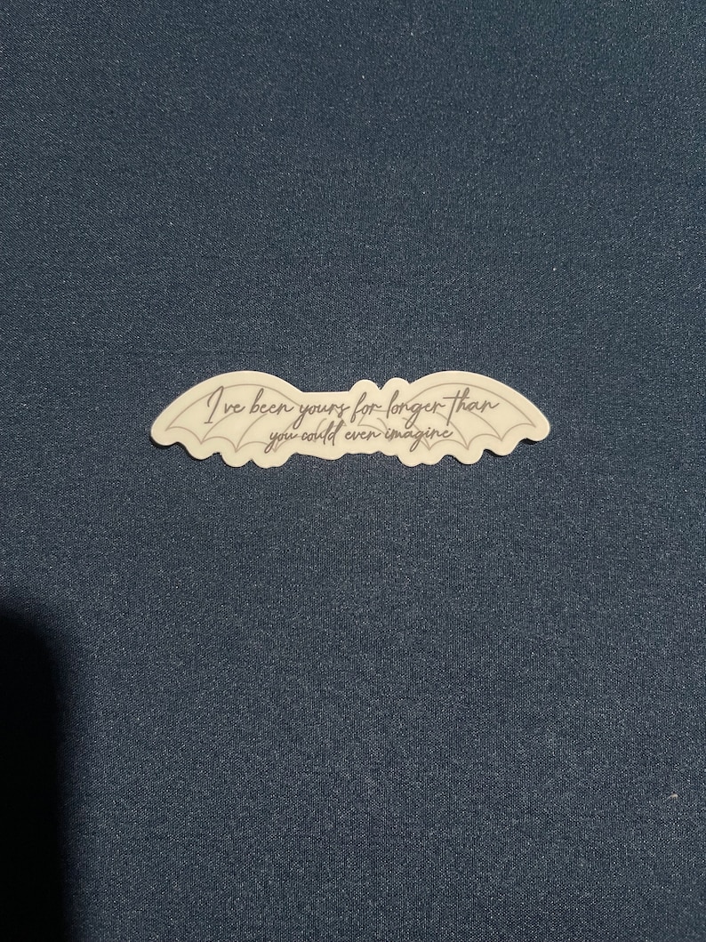 May include: A white sticker with a black outline of wings and the text "I've been yours for longer than you could even imagine".
