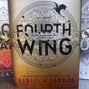 May include: A book cover with a black and white illustration of a dragon and clouds. The title of the book is "Fourth Wing" and the author is Rebecca Yarros. The book cover has a gold background with a black border.