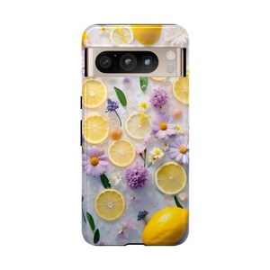 May include: A phone case with a white background and a design of lemons and flowers. The lemons are cut in half and the flowers are purple and white.