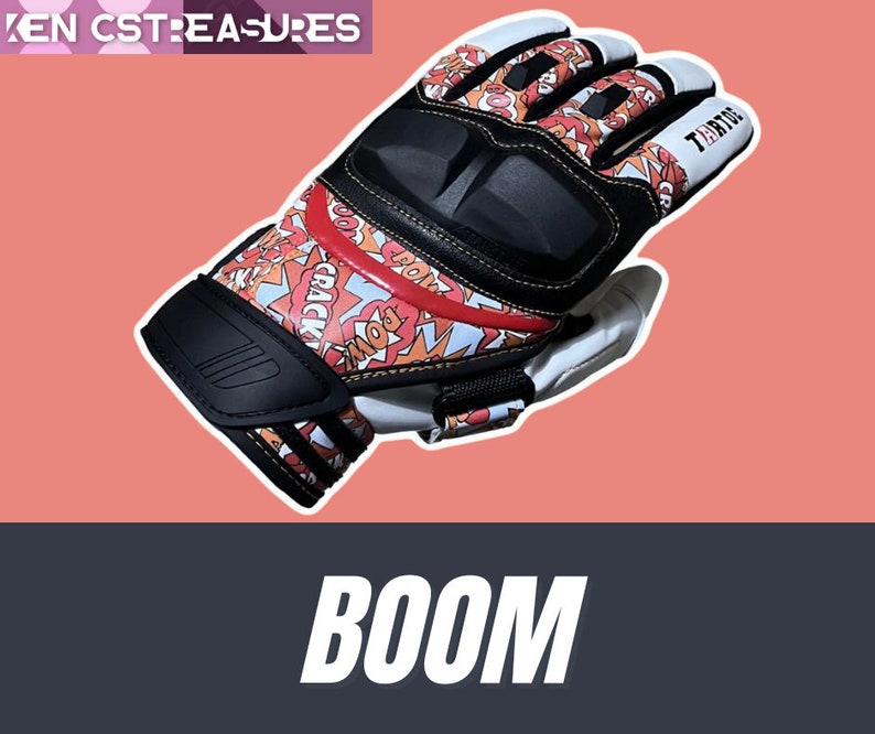 May include: A red, white, and black motorcycle glove with a comic book design featuring the words "BOOM", "POW", and "CRACK". The glove has a black knuckle guard and a white wrist strap with the word "TERTUE" printed on it.