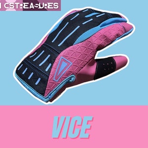 May include: Pink and blue motorcycle gloves with black accents and a triangle logo. The gloves have a textured pattern and are designed for grip and protection.