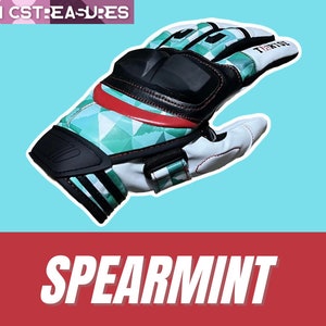 May include: A pair of green, white, and black motorcycle gloves with a geometric pattern. The gloves have knuckle protection and a red accent on the back of the hand. The text "TIGER" is printed on the back of the glove. The gloves are called "Spearmint".