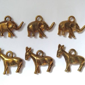 May include: Six gold-tone metal charms, three are elephants and three are donkeys. The charms are detailed and have a vintage look.