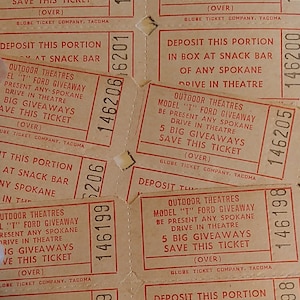 May include: Close-up of several vintage paper tickets for a drive-in theatre. The tickets are beige with red text and have the words "Outdoor Theatres" and "Model "T" Ford Giveaway" printed on them. The tickets have a unique serial number printed on each one.