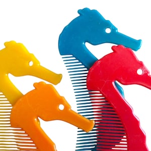 May include: Four colorful seahorse-shaped combs in yellow, orange, blue, and red. Each comb features a seahorse head design with a hole for hanging and teeth for combing hair. The combs are made of plastic.
