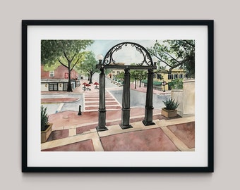 Puede incluir: Pintura a la acuarela de una escena callejera enmarcada en un borde negro. La obra presenta un arco decorativo con tres columnas en primer plano, que conduce a un paso de peatones y edificios. Los árboles y las sombrillas rojas añaden color a la escena.