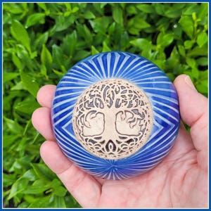 May include: A blue ceramic sphere with a white tree of life design. The sphere has a striped pattern.