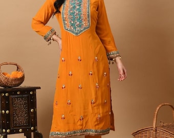 May include: A mustard yellow kurta and palazzo set with intricate embroidery and mirror work. The set features a round neckline and three-quarter sleeves. The palazzo pants have a wide leg and a straight fit.