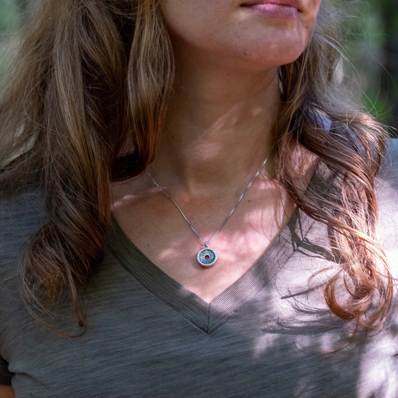 Sterling silver chakra charm Centering Pendant necklace on model.