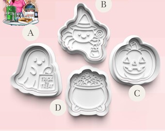 May include: Four white plastic Halloween-themed cookie cutters. The shapes include a ghost holding a trick-or-treat bag, a spider wearing a witch hat, a jack-o'-lantern, and a cauldron filled with candy. The cutters are displayed on a light pink background.